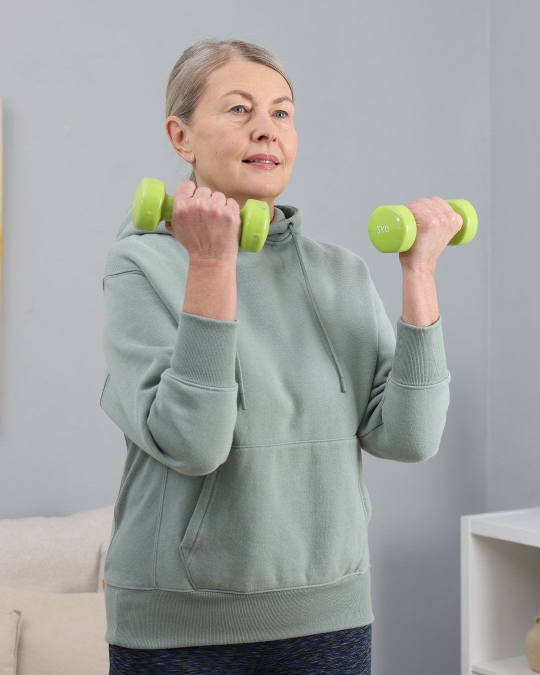 Woman exercising with green dumbbells.